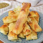 Wonton mozzarella sticks made in the air fryer stacked o a plate.