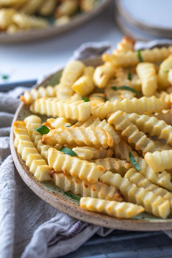 A close up of air fried crinkle cut fries.