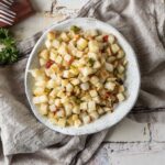 Home fries after air frying in a bowl shown close up.