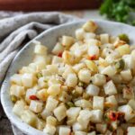 Home fries after air frying in a bowl shown close up.