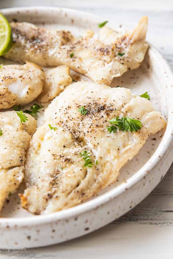 Close-up of a piece of tilapia on a serving plate.