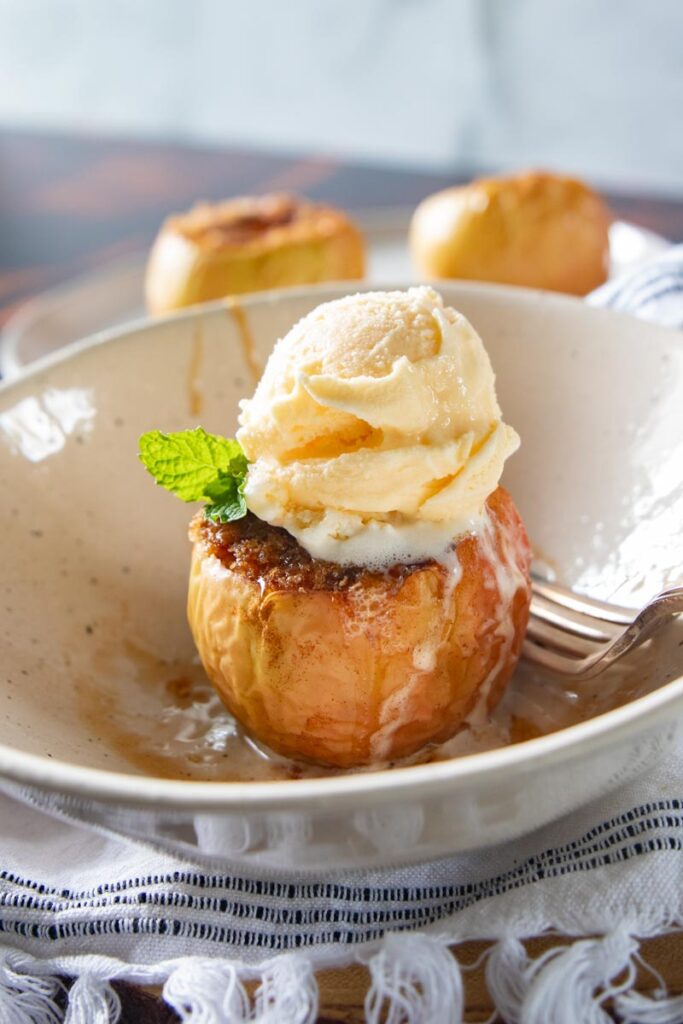 air fryer baked apple in a bowl with ice cream on top