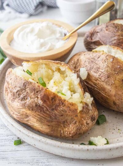 Baked Potato split open with butter on a plate